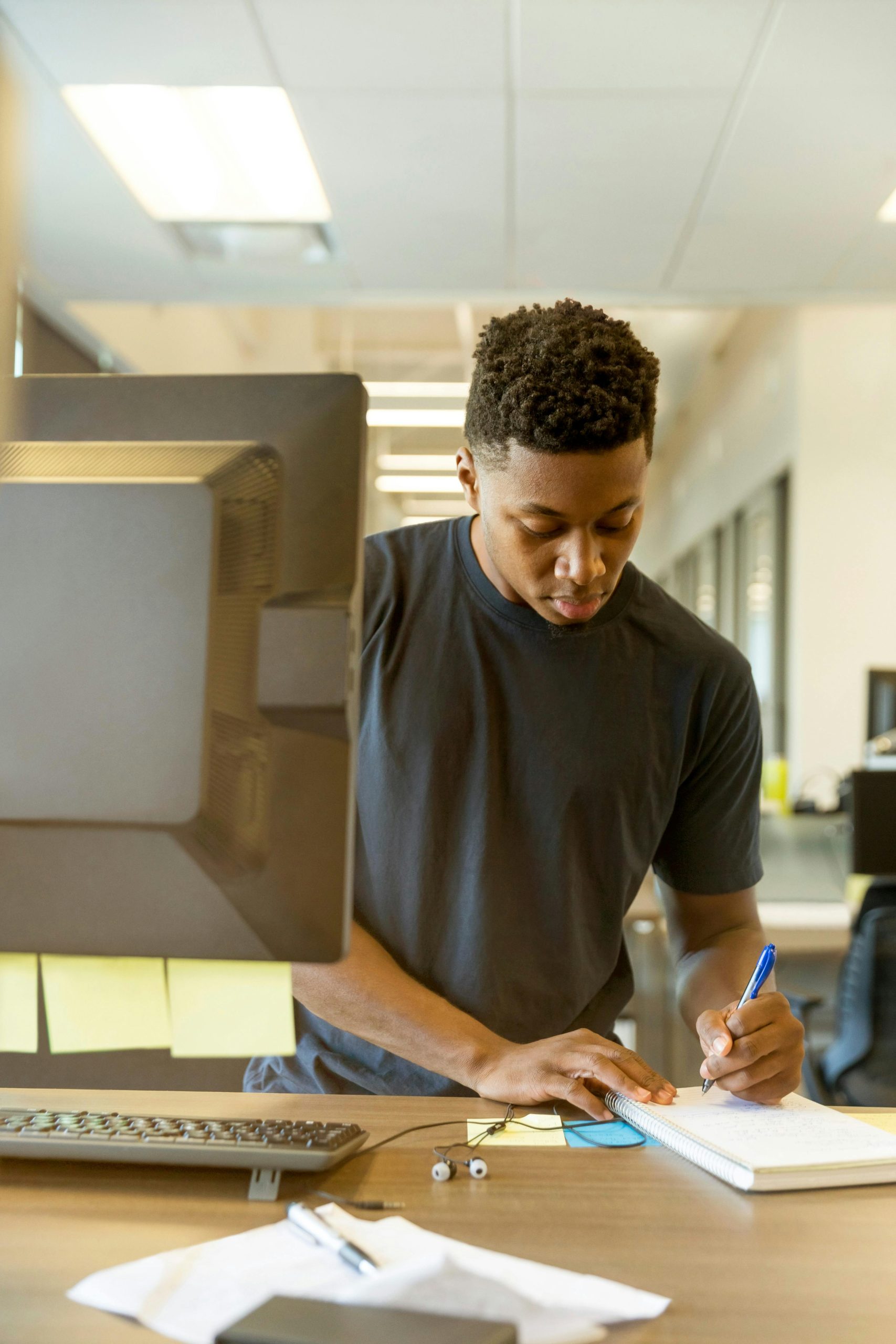 Young man intensely focused on his work at a modern tech office.